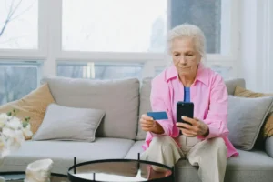 Privacy Policy 1 Senior woman using smartphone and holding a credit card, representing secure online activity and privacy